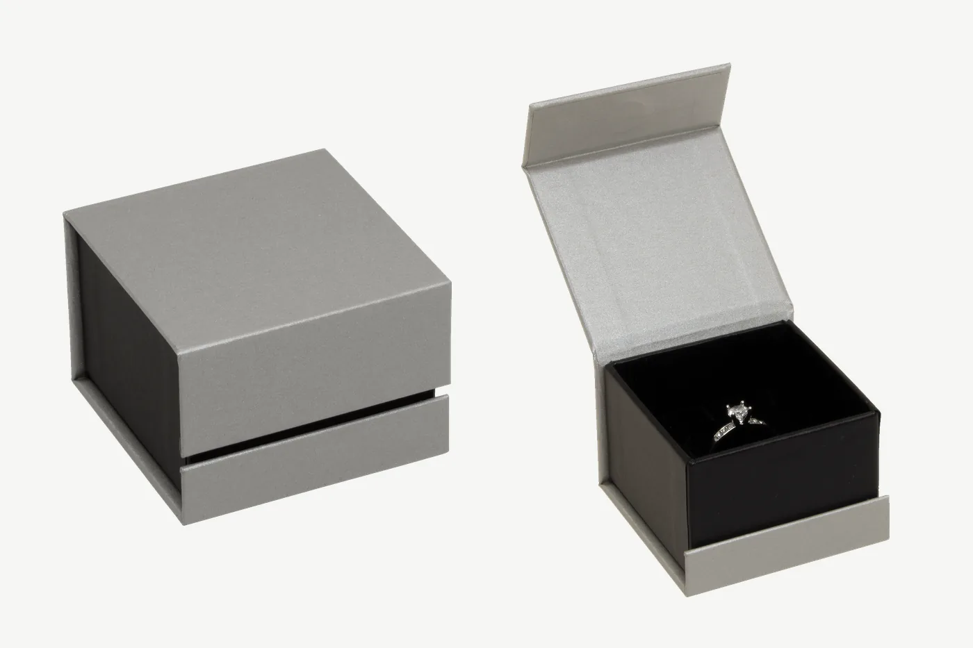 Klappschachtel 50 × 50 × 35 mm in Silber/Schwarz, links geschlossen, rechts geöffnet mit silbernem Deckelfutter und einem Ring in der schwarzen Einlage